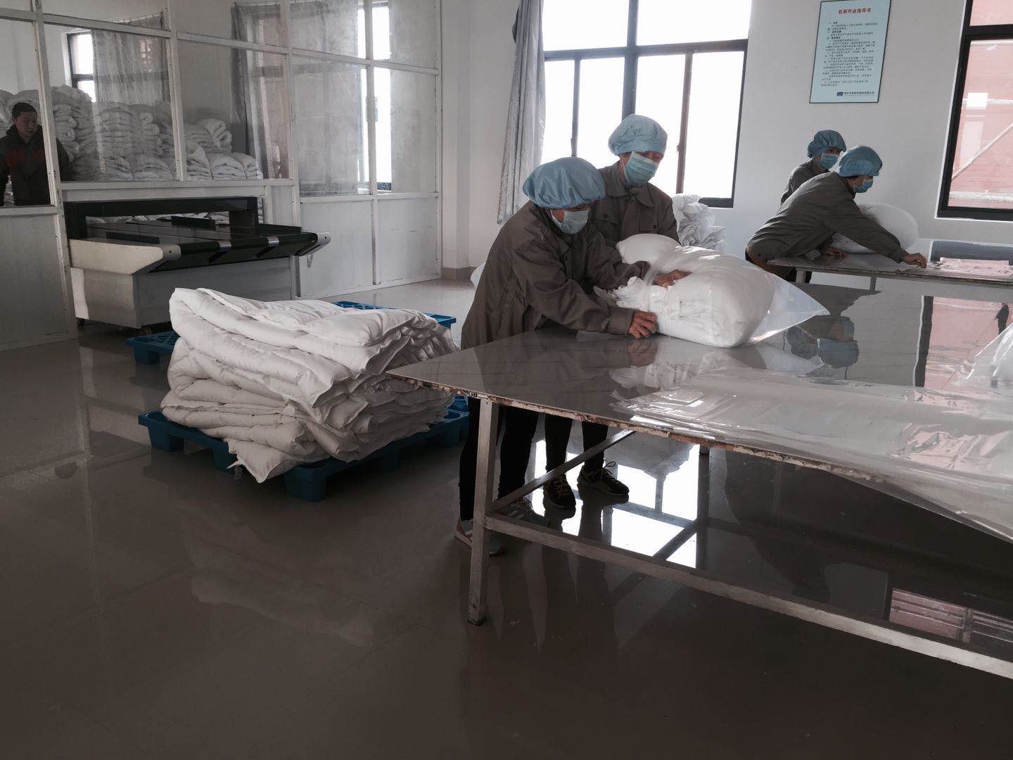 several workers are packing the bedding products